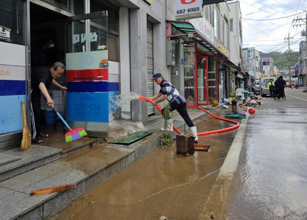 People clean shops and streets in Goseong on the northeastern South Korean coast on Friday, after the region suffered flooding the previous day due to Typhoon Khanun. (Yonhap)