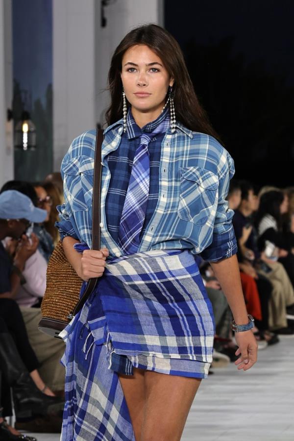 A model walking down the runway wearing a plaid shirt and tie at the Ralph Lauren fashion show during New York Fashion Week September 2024 in Bridgehampton, New York