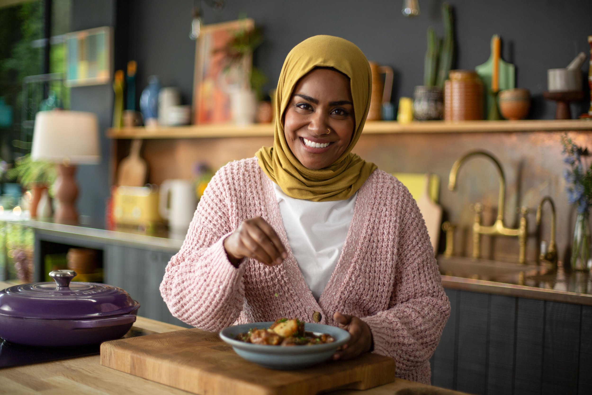 Bake Off winner Nadiya Hussain sprinkling salt on some potatoes on BBC Show Nadiya's Cook Once, Eat Twice